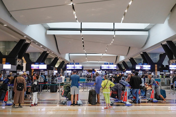Des voyageurs font la queue à un comptoir d’enregistrement à l’aéroport international  de Johannesburg le 27 novembre 2021, après que plusieurs pays ont interdit les vols en provenance d’Afrique du Sud. (Photo de Phill Magakoe / AFP via Getty Images).