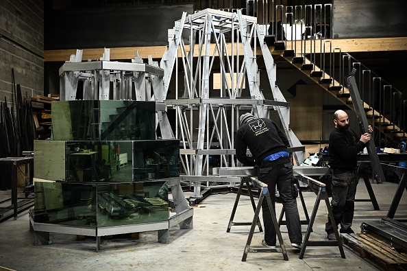 Des ouvriers participent à la construction d'un sapin de Noël de 11 mètres de haut entièrement en acier (recyclable) et en verre (recyclé) conçu par le designer français Arnaud Lapierre.  (PHILIPPE LOPEZ/AFP via Getty Images)