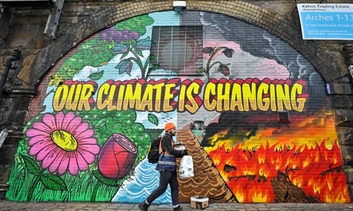 Des artistes peignent sur un mur près de l'autoroute Clydeside, à proximité du Scottish Events Center qui accueille la 26e Conférence des Nations unies sur le changement climatique (COP26) à Glasgow, en Écosse, le 13 octobre 2021. (Jeff J Mitchell/Getty Images)
