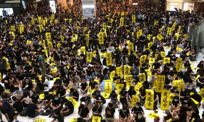 Des manifestants tenant des banderoles s'opposant au projet de loi sur l'extradition dans le New Town Plaza de Hong Kong, le 5 août 2019. (Juliana Chu/Epoch Times)