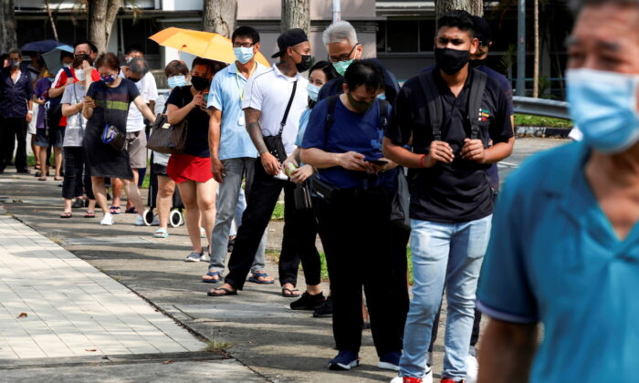 Des personnes font la queue à l'extérieur d'un centre de dépistage rapide du Covid-19, à Singapour, le 21 septembre 2021. (Edgar Su/Reuters)