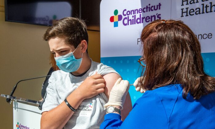 Max Zito, 13 ans, est vacciné par l'infirmière Karen Pagliaro au centre de vaccination de masse Hartford Healthcares au Connecticut Convention Center à Hartford, Conn. le 13 mai 2021. (Joseph Prezioso/AFP via Getty Images)