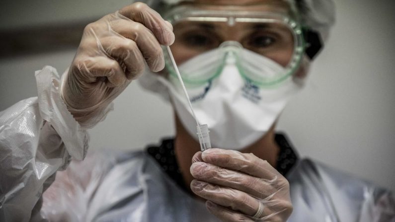 Une assistante médicale prélève un échantillon sur un patient pour un test de détection du Covid-19. (JEFF PACHOUD/AFP via Getty Images)