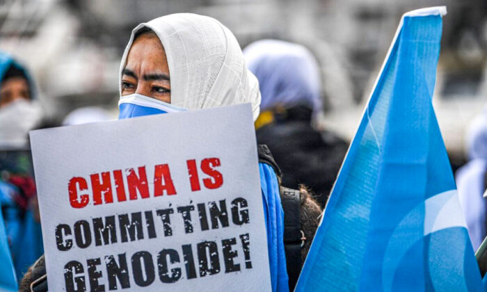 Des membres de la minorité musulmane ouïghoure tiennent des pancartes et le drapeau du Turkestan oriental alors qu'ils manifestent pour demander des nouvelles de leurs proches et exprimer leur inquiétude concernant la ratification d'un traité d'extradition entre la Chine et la Turquie, près du consulat de Chine à Istanbul, le 8 mars 2021, lors de la Journée internationale de la femme. (Ozan Kose/AFP via Getty Images)