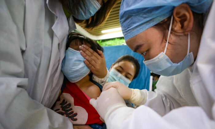 Un enfant se fait vacciner contre le coronavirus Covid-19 à Wuhan, dans la province de Hubei, en Chine, le 12 novembre 2021. (STR/AFP via Getty Images)