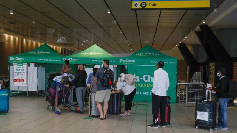 Des voyageurs font la queue dans une zone destinée aux tests PCR du Covid-19 à l'aéroport international OR Tambo de Johannesburg, le 27 novembre 2021. (Photo de PHILL MAGAKOE/AFP via Getty Images)
