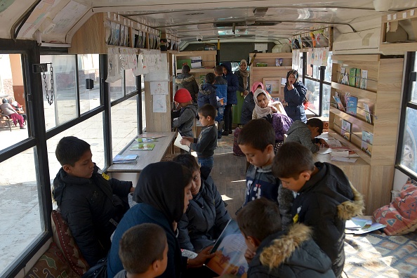 -Des enfants se tiennent à l'intérieur d'une bibliothèque mobile qui a ouvert ses portes pour la première fois depuis le retour au pouvoir des talibans, à Kaboul le 5 décembre 2021. Photo Ahmad SAHEL ARMAN/AFP via Getty Images.