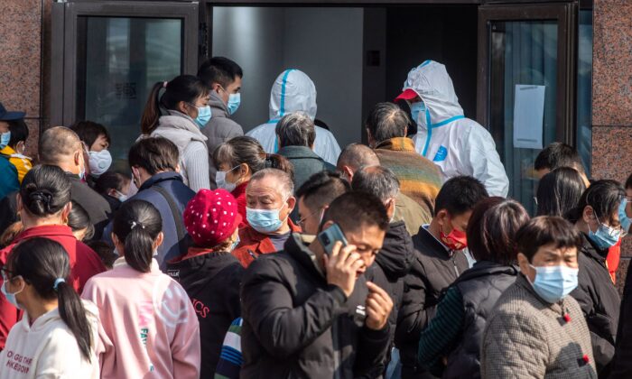 Des personnes attendent de passer des tests d'acide nucléique pour le coronavirus Covid-19 lors d'un test de masse à Ningbo, dans la province chinoise du Zhejiang (est), le 7 décembre 2021. (STR/AFP via Getty Images)