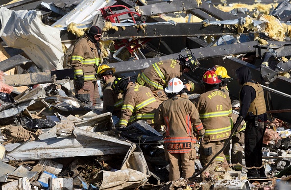 -Les secouristes fouillent ce qui reste de l'usine de bougies de Mayfield après sa destruction par une tornade, Kentucky, le 11 décembre 2021. Photo de John Amis / AFP via Getty Images.