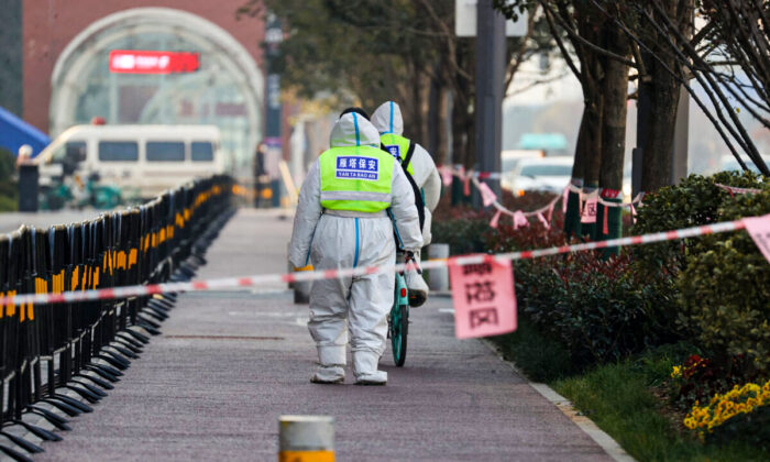 Des agents de sécurité marchent dans la zone soumise aux restrictions à la suite d’une récente propagation du Covid-19 dans la ville de Xi'an, province de Shaanxi, Chine, le 22 décembre 2021. (STR/AFP via Getty Images)