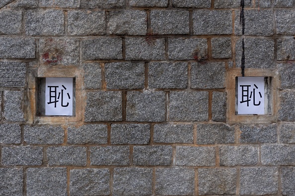 -Des morceaux de papier imprimés avec le caractère chinois "honte" sur le site d'une sculpture marquant la répression de 1989 par Pékin, enlevée de l'Université Lingnan de Hong Kong le 24 décembre 2021. Photo de Bertha WANG / AFP via Getty Images.