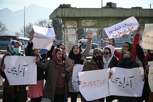 -Des femmes tiennent des pancartes lors d'une manifestation pour exiger la fin des exécutions extrajudiciaires d'anciens responsables de l'ancien régime, à Kaboul le 28 décembre 2021. Photo de Mohd RASFAN / AFP via Getty Images.
