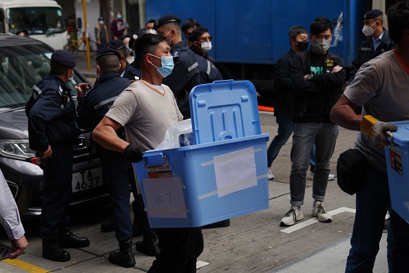 Un travailleur transporte une boîte de documents des bureaux de Stand News à Hong Kong le 29 décembre 2021. Photo de Daniel SUEN / AFP via Getty Images.