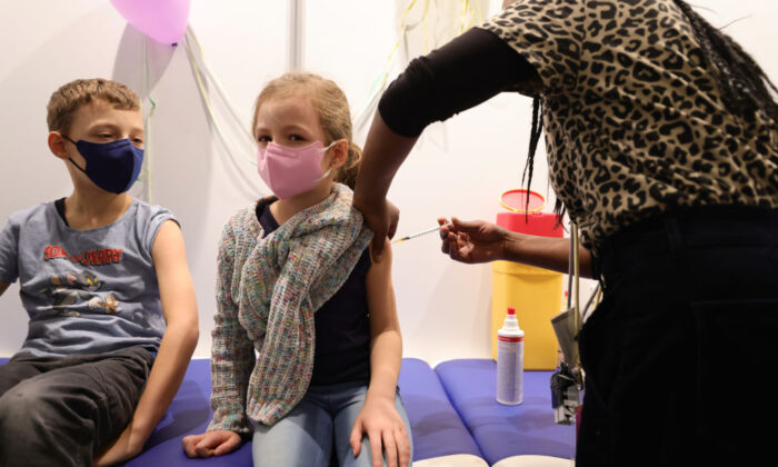 Des enfants reçoivent une dose du vaccin Covid-19 Pfizer-BioNTech dans le centre de vaccination Lanxess Arena à Cologne, en Allemagne, le 18 décembre 2021. (Andreas Rentz/Getty Images)