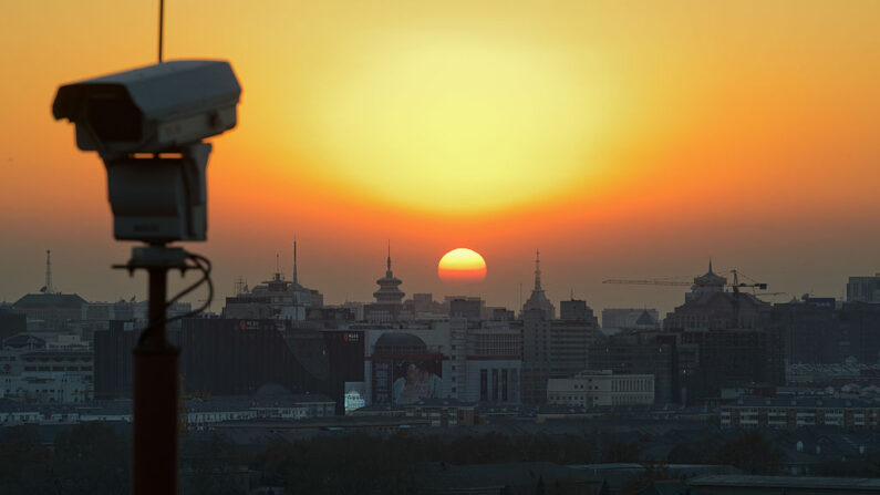 Soleil couchant sur la ligne d'horizon de Pékin derrière une caméra de surveillance, le 5 décembre 2013. (ED JONES/AFP via Getty Images)