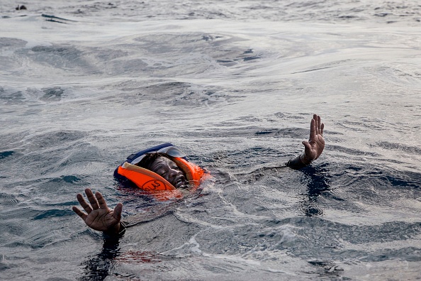 -Un migrant qui se noie tente de monter à bord d'un bateau. Photo Alessio Paduano /AFP via Getty Images.