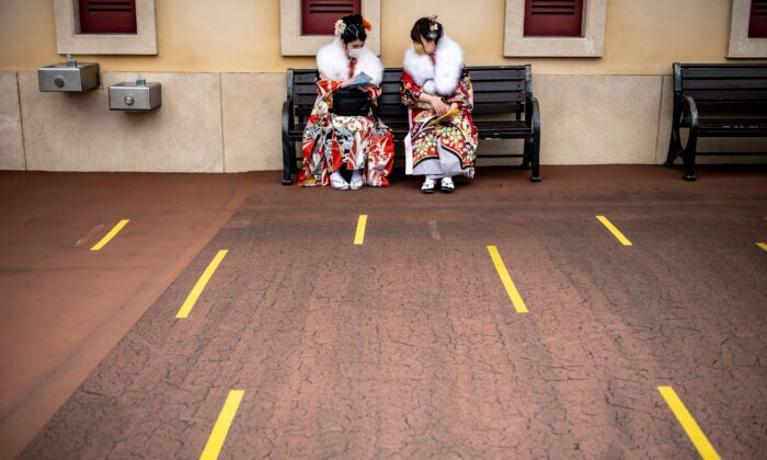Des jeunes femmes de 20 ans portant des kimonos attendent d'assister à une cérémonie de célébration du "Jour du passage à l'âge adulte", reportée en raison de la pandémie de Covid-19, à DisneySea à Urayasu, le 7 mars 2021. (PHILIP FONG/AFP via Getty Images)