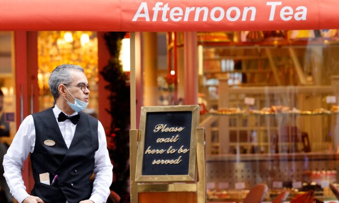 Un serveur attend des clients à l'extérieur d'un restaurant à Londres, le 21 décembre 2021. (Tolga Akmen/AFP via Getty Images)