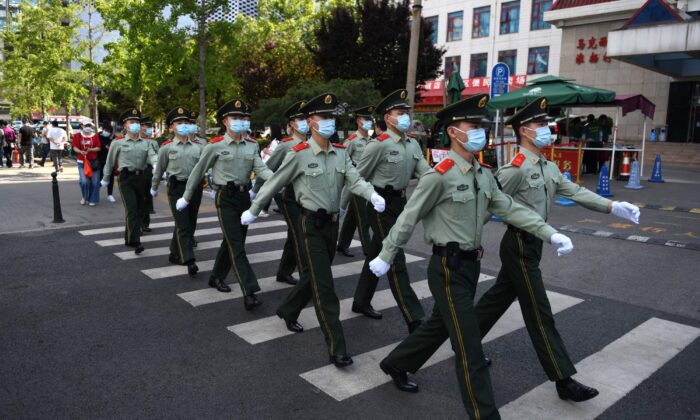 Des policiers paramilitaires patrouillent dans une zone commerciale lors de la journée de clôture de la Conférence consultative politique du peuple chinois (CCPPC) à Pékin, le 27 mai 2020. (Greg Baker/AFP via Getty Images)