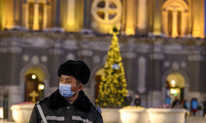 Un agent de sécurité portant un masque facial monte la garde à l'église Saint-Joseph pendant une messe à la veille de Noël à Pékin, le 24 décembre 2020. (Noel Cells/AFP via Getty Images)
