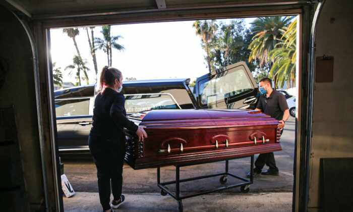 Des employés chargent le cercueil dans un corbillard à East County Mortuary à El Cajon, en Californie, le 15 janvier 2021. (Mario Tama/Getty Images)