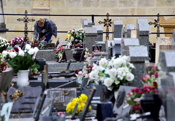 Photo d'illustration : une femme se recueillant sur une tombe. Crédit : GEORGES GOBET/AFP/Getty Images.