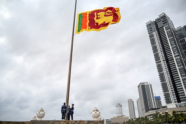 -Des soldats se tiennent au garde-à-vous alors que le drapeau national est abaissé dans le cadre d'une cérémonie quotidienne sur la promenade Galle Face Green à Colombo le 17 mai 2020. Photo par ISHARA S. KODIKARA/AFP via Getty Images.