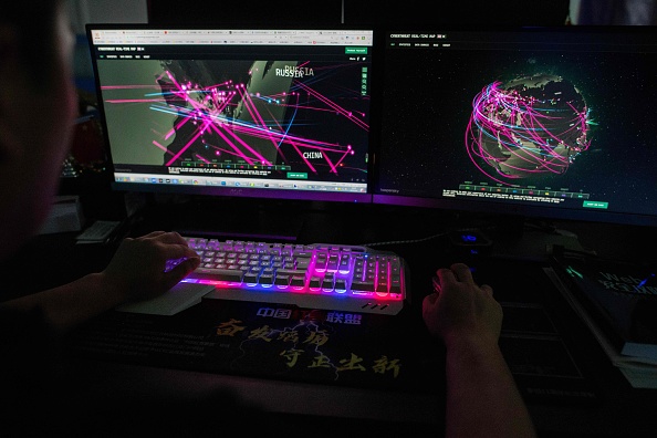 -Illustration- Membre du groupe de piratage Red Hacker Alliance utilise un site Web qui surveille les cyberattaques mondiales. Photo de NICOLAS ASFOURI/AFP via Getty Images.