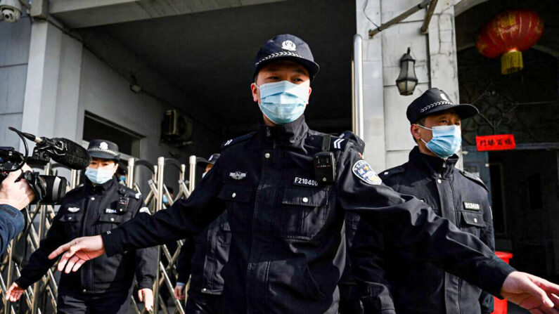 Des policiers sécurisent une entrée latérale après l'arrivée de véhicules de police au tribunal populaire intermédiaire de Dandong, dans la province chinoise du Liaoning (nord-est), le 19 mars 2021. (Noel Celis/AFP via Getty Images)