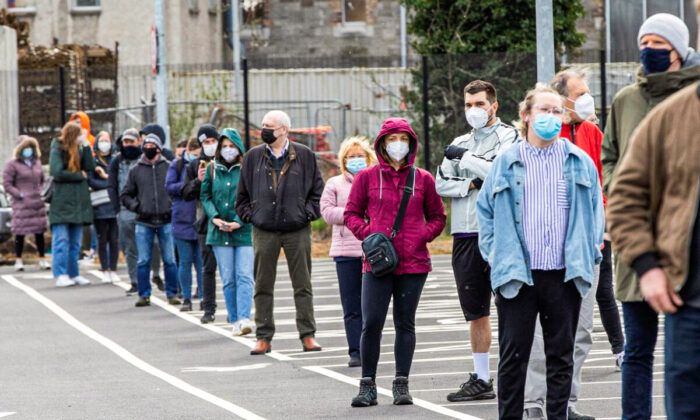 Des personnes font la queue pour recevoir un test par écouvillon pour le Covid-19 dans un centre de dépistage mobile sans rendez-vous géré par le service des ambulances à Dublin, en Irlande, le 25 mars 2021. (Paul Faith/AFP via Getty Images)