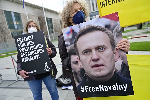 Des manifestants affichent un portrait du critique du Kremlin Alexeï Navalny et une banderole indiquant "Liberté pour le prisonnier politique Navalny" lors d'une manifestation à Berlin, en Allemagne, le 21 avril 2021. Photo de JOHN MACDOUGALL/AFP via Getty Images.
