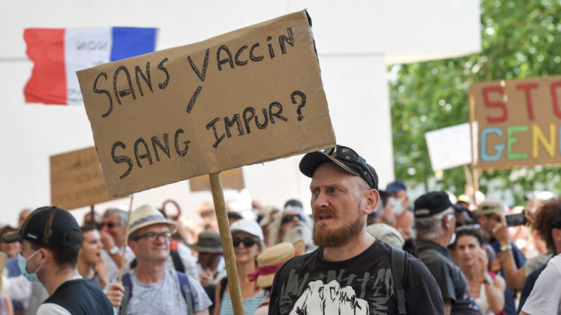 Un manifestant tient une pancarte sur laquelle on peut lire "Sans vaccin, sang impur ?" lors d'une journée nationale de protestation contre l'obligation vaccinale pour certains travailleurs, à Nantes, dans l'ouest de la France, le 14 août 2021. (Photo par SEBASTIEN SALOM-GOMIS/AFP via Getty Images)