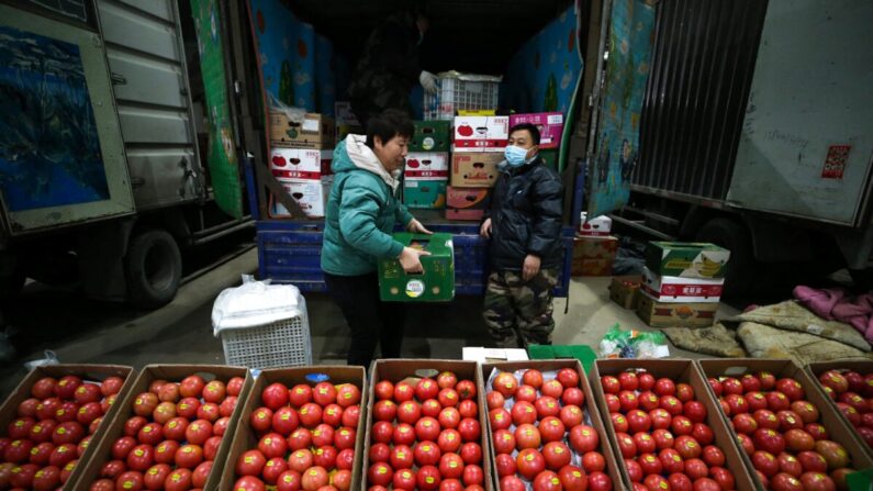 Dans un marché à Shenyang, des vendeurs de tomates attendent les clients le 9 décembre 2021, dans la province du Liaoning, en Chine. (STR/AFP via Getty Images)
