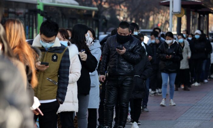 Des personnes font la queue pour subir un test de dépistage du Covid-19 à Xi'an, dans la province chinoise du Shaanxi (nord), le 21 décembre 2021. Une recrudescence de nouveaux cas a fait craindre une transmission plus large avant une saison de voyage chargée. (STR/AFP via Getty Images)