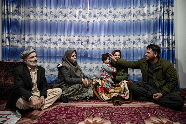 Hamid Safi, un chauffeur de taxi a trouvé Sohail Ahmadi sur le sol à l'aéroport de Kaboul et a retrouvé sa famille, tapote Sohail, à Kaboul le 9 janvier 2022. Photo de MOHD RASFAN/AFP via Getty Images.