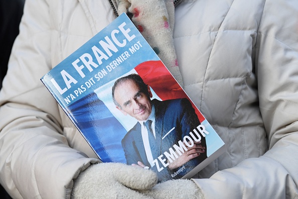 Une femme tient le livre d'Eric Zemmour, leader du parti "Reconquete !" (BERTRAND GUAY/AFP via Getty Images)