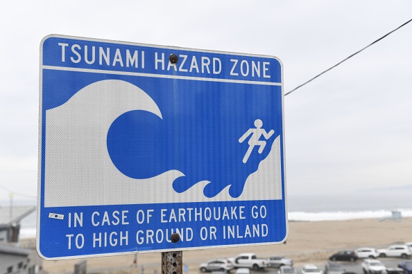-Un panneau de zone à risque de tsunami est affiché près d'une plage à El Segundo, en Californie, le 15 janvier 2022. Photo de Patrick T. FALLON / AFP via Getty Images.
