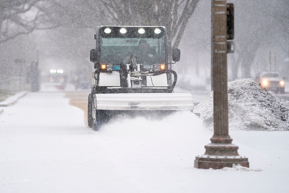 Une balayeuse à neige nettoie les trottoirs près du National Mall à Washington, DC, lors d'une tempête hivernale le 16 janvier 2022. Photo de Stefani Reynolds / AFP via Getty Images.