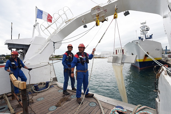 Des membres d'équipage du navire Ifremer Europe tiennent un filet qui recueille des échantillons dans l'eau à La Seyne-sur-Mer, dans le sud de la France. Photo ANNE-CHRISTINE POUJOULAT/AFP via Getty Images.