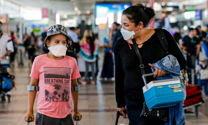 Des passagers marchent avec des masques de protection à l'aéroport international Arturo Merino Benitez, à Santiago, le 3 mars 2020. (Javier Torres/AFP via Getty Images)