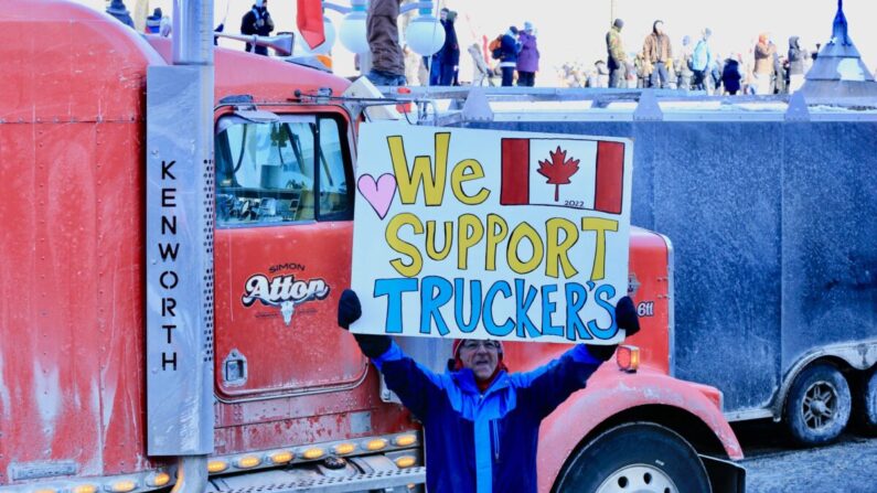 Manifestant tenant une pancarte de soutien au camionneurs sur la colline du Parlement à Ottawa lors des manifestations liées au Convoi de la liberté, le 29 janvier 2022. (Jonathan Ren/Epoch Times)