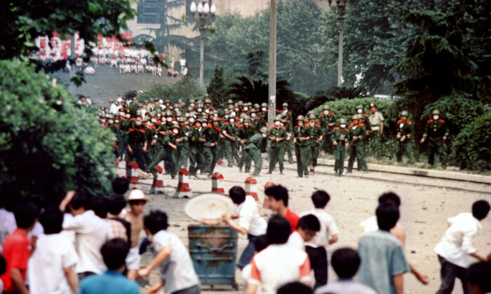 Des citoyens et des étudiants chinois de Chengdu, capitale de la province du Sichuan, lancent des pierres sur une troupe, le 4 juin 1989, lors d'une émeute consécutive à la proclamation de l'état martial dans la ville. Une série de manifestations pro-démocratie a été déclenchée par la mort, le 15 avril, de l'ancien chef du parti communiste, Hu Yaobang. Dans une démonstration de force, les dirigeants chinois ont déversé leur fureur et leur frustration sur les étudiants dissidents et leurs partisans pro-démocratie. (-/AFP via Getty Images)