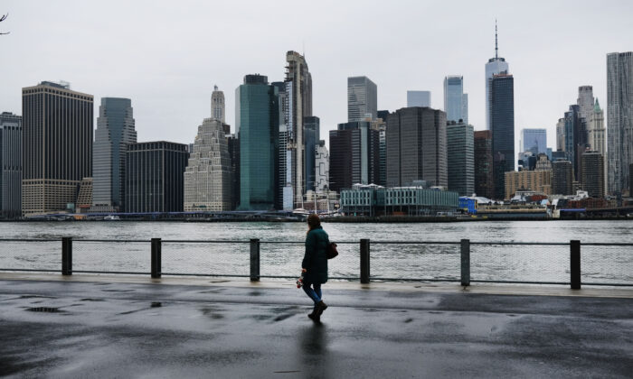 Une personne marche à Brooklyn tandis que le sud de Manhattan se profile à l'arrière-plan, à New York, le 28 mars 2020. (Spencer Platt/Getty Images)