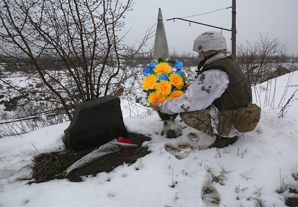 Un militaire ukrainien dépose des fleurs à l'endroit où l'un de ses amis a été tué sur la ligne de front avec les séparatistes soutenus par la Russie dans la région de Donetsk, le 2 février 2022. Photo par ANATOLII STEPANOV/AFP via Getty Images.