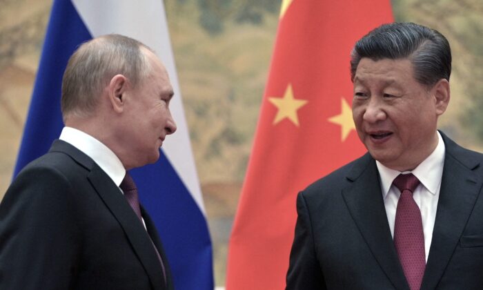 Le président russe Vladimir Poutine (à gauche) et le président chinois Xi Jinping arrivent pour poser  lors d'une rencontre à Pékin, le 4 février 2022. (Photo par ALEXEI DRUZHININ/Sputnik/AFP via Getty Images)