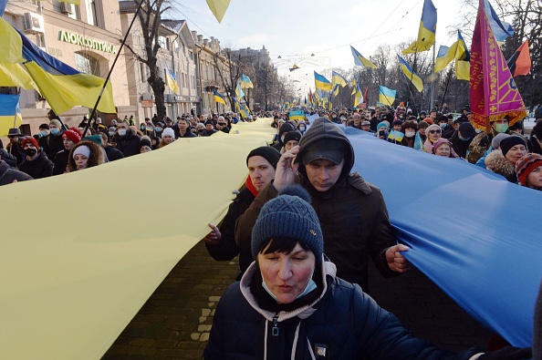 Des manifestants tiennent des drapeaux ukrainiens lors d'une marche pour l'unité au milieu de la montée des tensions avec la Russie, à Kharkiv, dans l'est de l'Ukraine, le 5 février 2022. Photo de Sergey BOBOK / AFP via Getty Images.