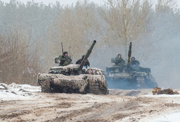 -Des militaires ukrainiens de la 92e brigade mécanisée utilisent des chars, des canons et d'autres véhicules blindés pour mener des exercices de tir réel dans la région de Kharkiv, le 10 février 2022. Photo de Sergey BOBOK / AFP via Getty Images.