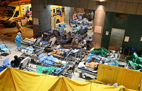 -Les gens sont allongés dans des lits d'hôpitaux à l’extérieur du centre médical Caritas à Hong Kong le 16 février 2022. Photo de Peter PARKS / AFP via Getty Images.