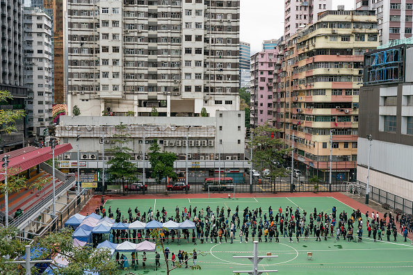 Les résidents font la queue dans une station de test de fortune le 18 février 2022 à Hong Kong. Le gouvernement de Hong Kong déploie des tests COVID-19 à l'échelle de la ville avec le soutien des autorités du continent. Photo par Anthony Kwan/Getty Images.