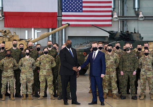 -Le secrétaire américain à la Défense Lloyd Austin serre la main du ministre polonais de la Défense Mariusz Blaszczak devant des soldats polonais et américains à la 33e base aérienne de l'armée de l'air polonaise le 18 février 2022. Photo de JANEK SKARZYNSKI/AFP via Getty Images.